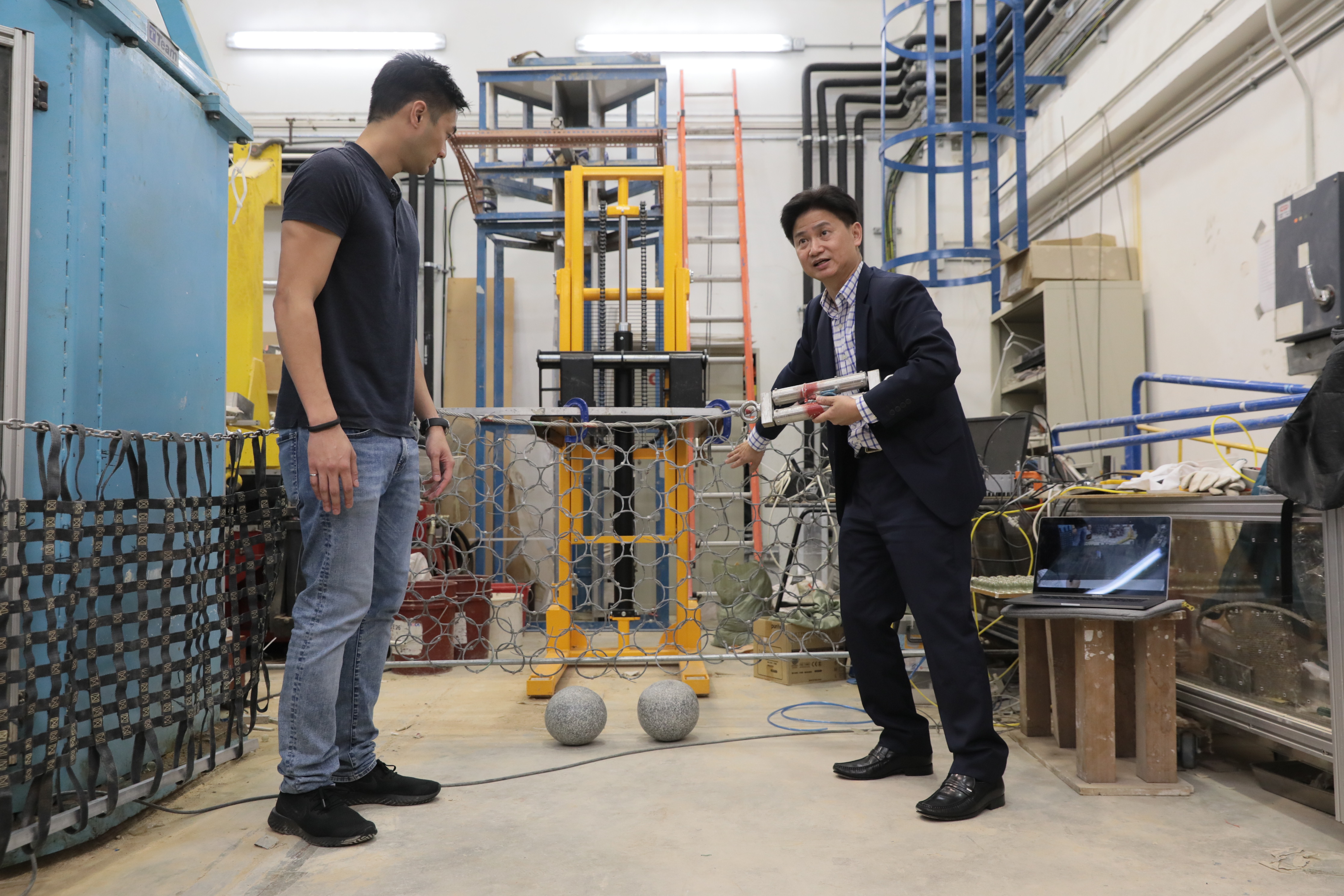 Prof. Charles Ng (right) and Dr. Choi explain how the newly-design multiple flexible barrier system work.