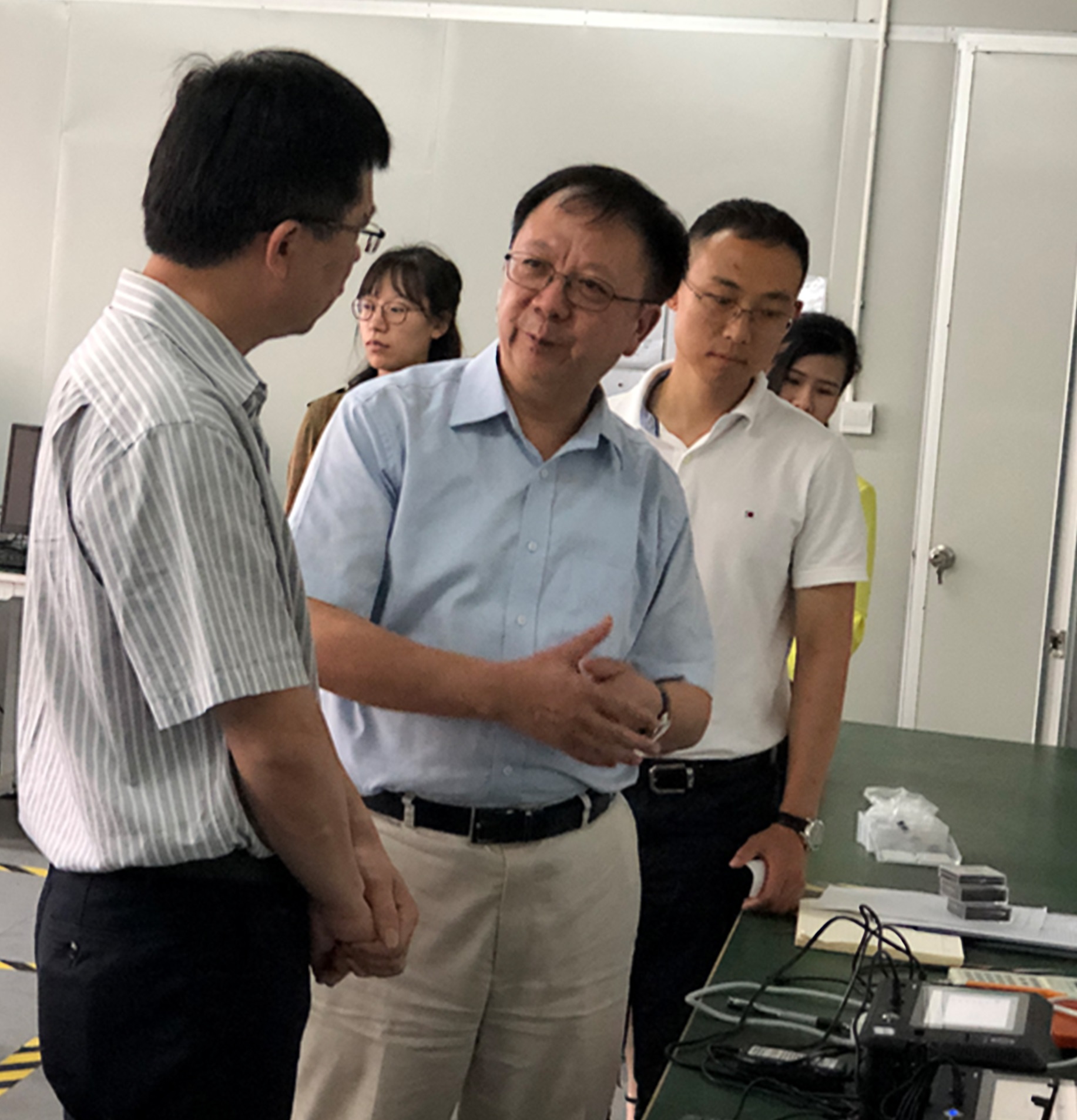 Prof. Wen (Middle) and Dr. Gao (right) introduce the theories behind their novel detection device in their research base at Shenzhen. 