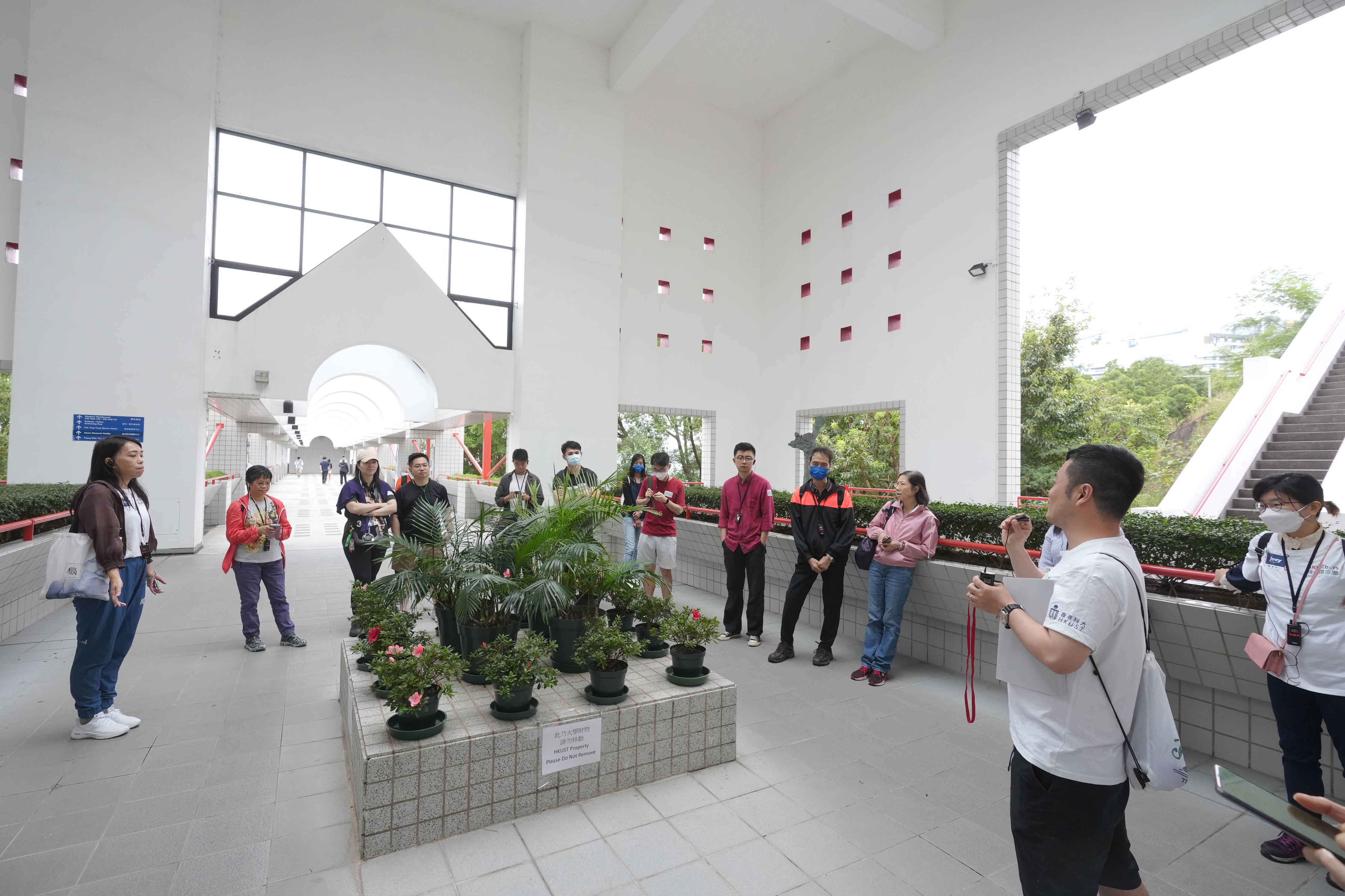 另一个由科大校友带领的导赏团穿梭校园各处，介绍各个景点和他们背后的故事。图中的景点是智慧石，是位于通住海边连接桥的方形大石，相传学生如果能成功跳过智慧石，成绩便可「过三爆四」，如跳不过则会因成绩退步而被踢出校。