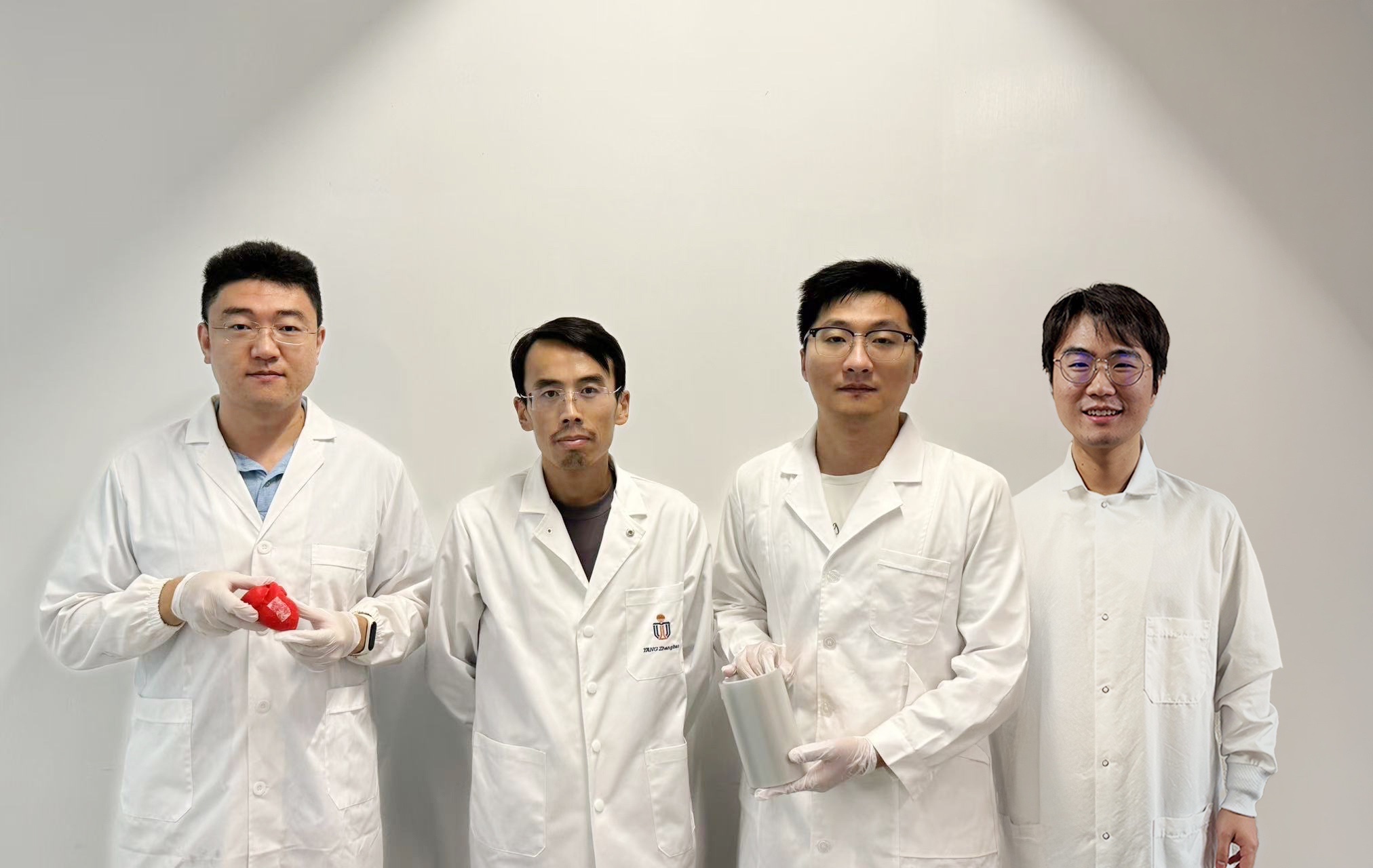 Prof. YANG Zhengbao (second left), Associate Professor at HKUST’s Department of Mechanical and Aerospace Engineering, with the three co-first authors of the study: HKUST postdoctoral fellow Dr. LI Xuemu (second right, holding a roll of printed glycine films), CityU PhD graduate Dr. ZHANG Zhuomin (first right) and PhD Student ZHENG Yi (first left, with a glycine patch in his hands).