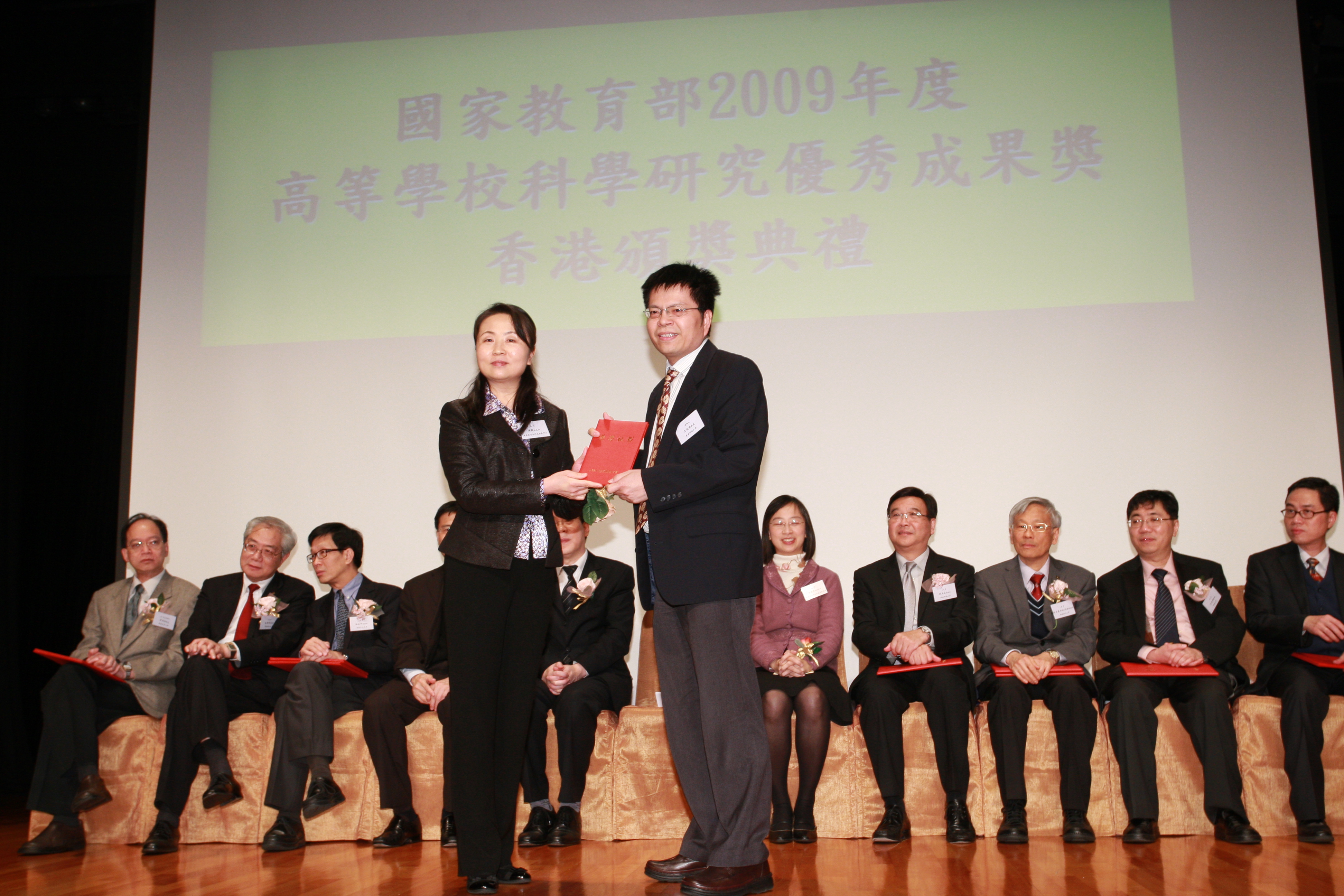 王 文 雄 教 授 （ 右 ） 接 受 国 家 教 育 部 科 技 发 展 中 心 副 主 任 周 静 女 士 颁 发 奖 励 证 书	