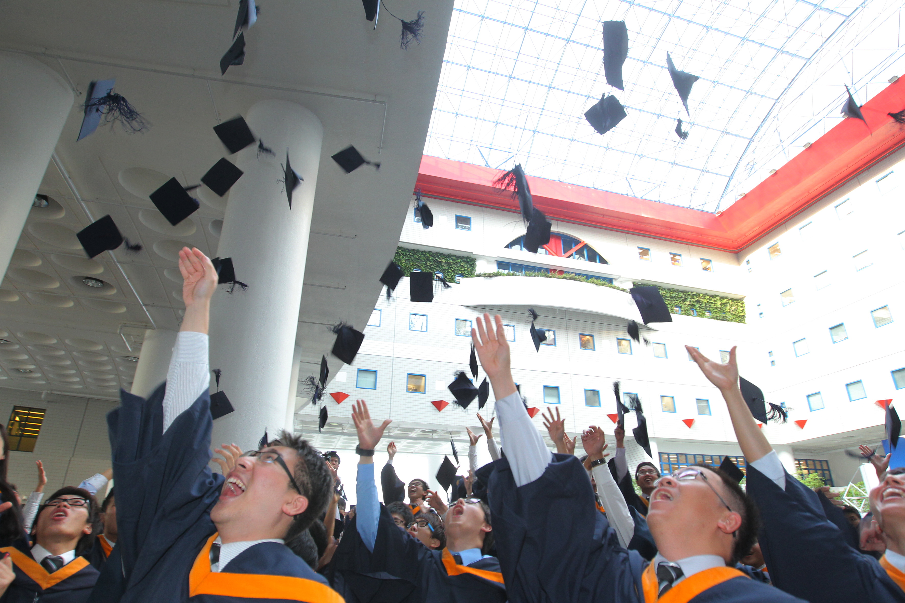Graduates tossing their caps high in elation as the Congregation concludes.