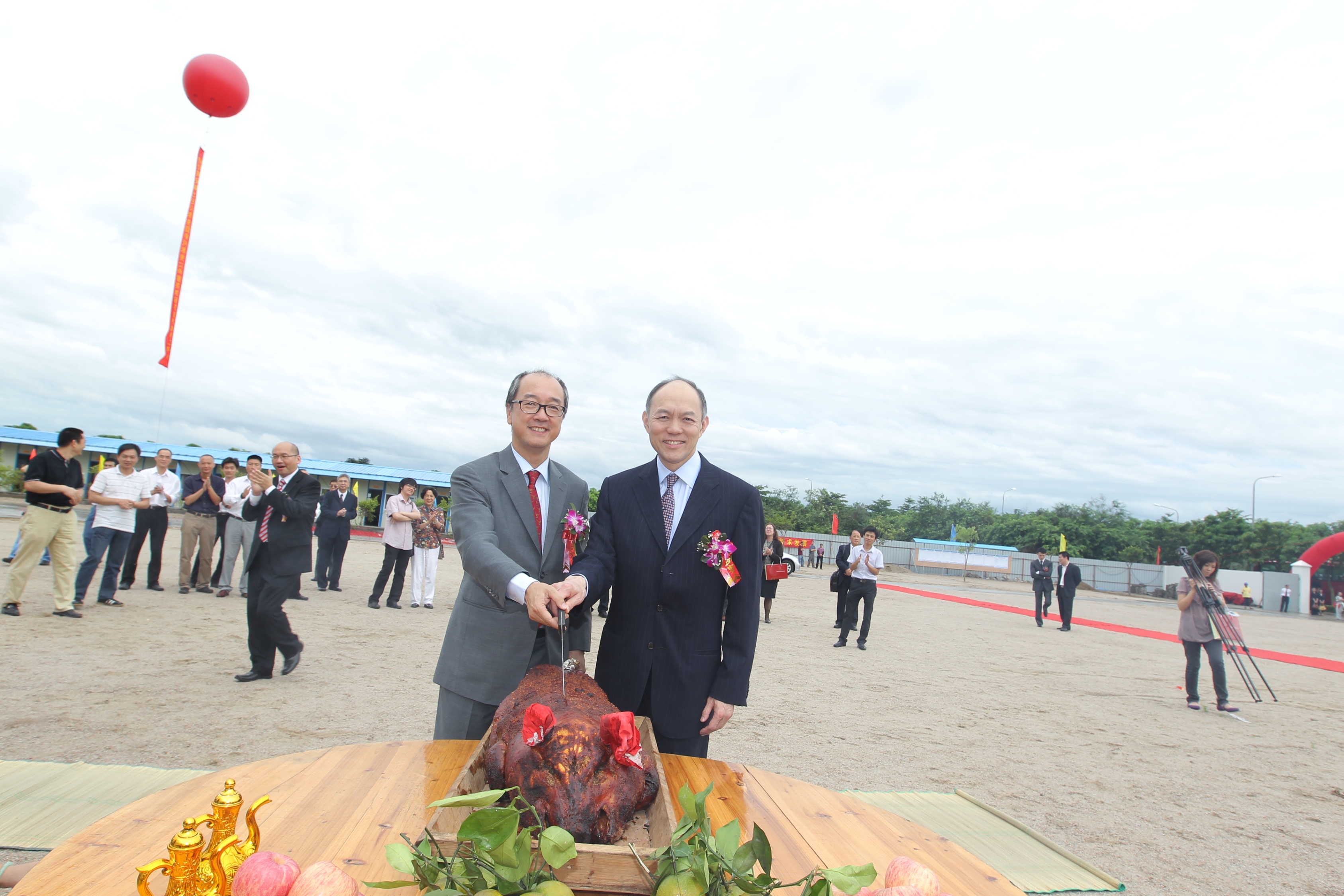  President Tony Chan (left) and Mr Ian Fok perform the pig cutting ceremony on the construction site of the HKUST Fok Ying Tung Graduate School Building