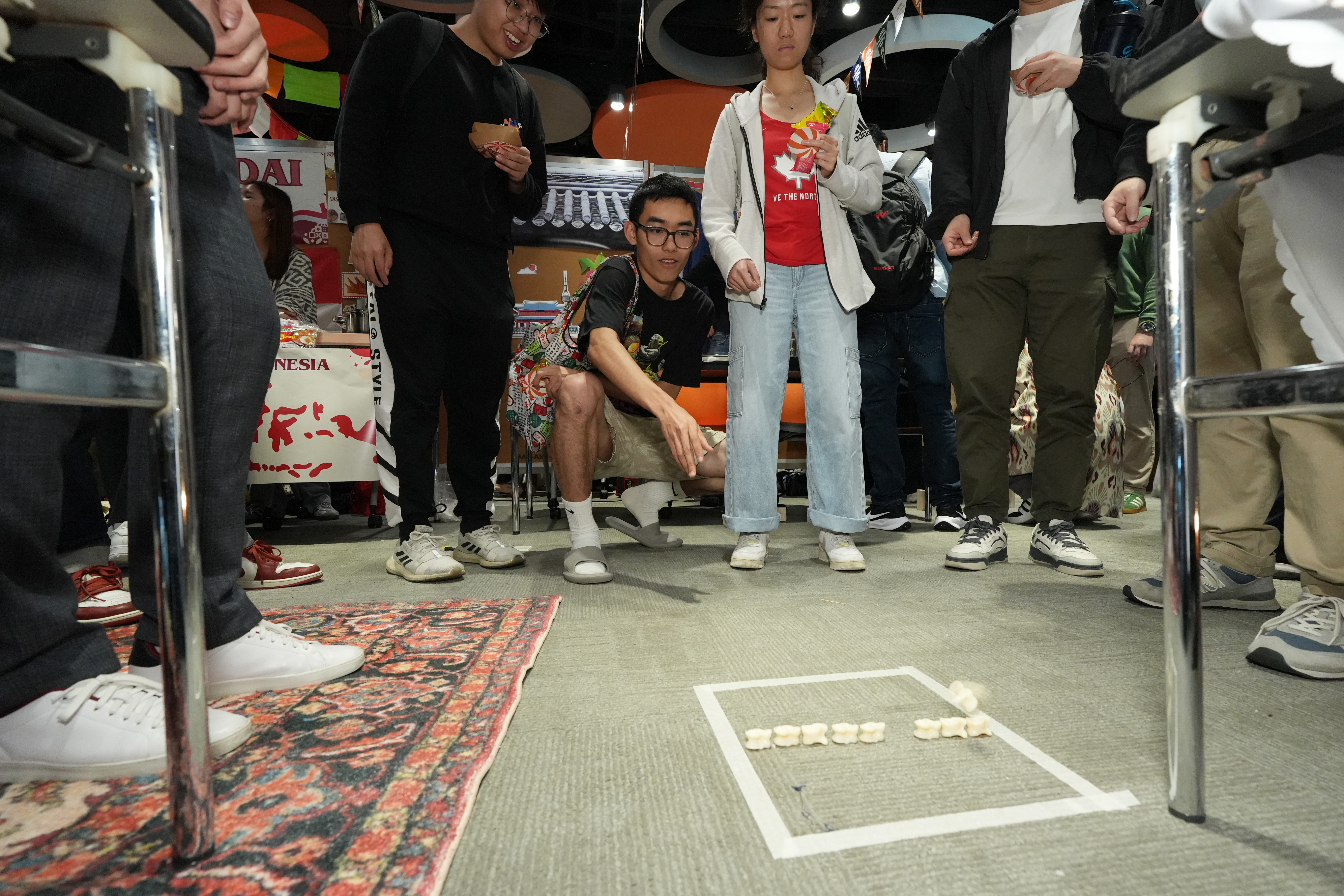 哈薩克斯坦同學介紹當地傳統遊戲「Assyk」。同學們輪流以彈珠嘗試把對方的骰子打出框界以外。