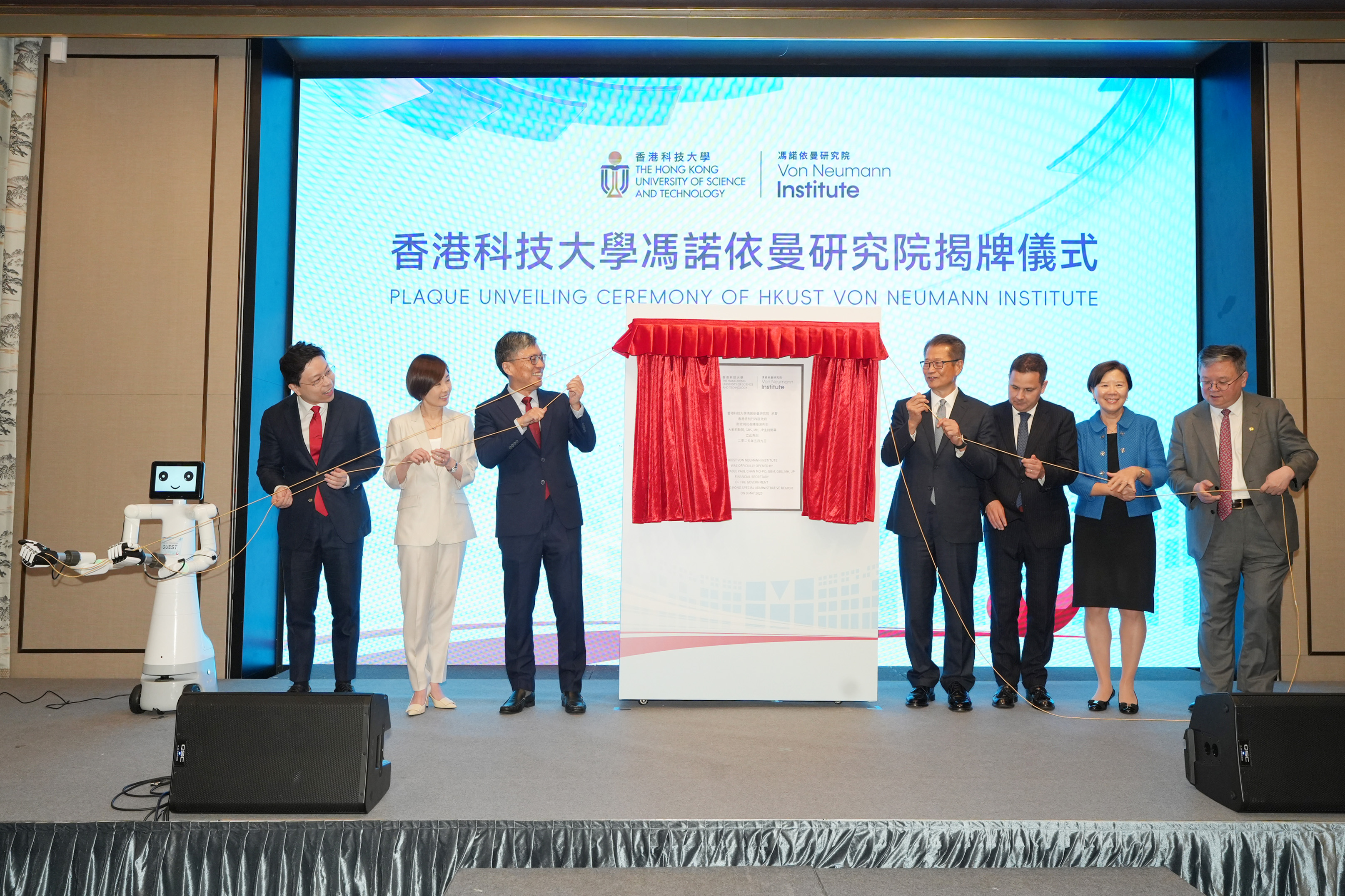 HKUST establishes the Von Neumann Institute (VNI) today. Mr. Paul CHAN, Financial Secretary of HKSAR (fourth right); Dr. Pál KERTÉSZ, Consul General of Hungary in Hong Kong (third right); Ms. Clara CHAN Ka-Chai, Chief Executive Officer of HKIC (second left); Prof. Harry SHUM, HKUST Council Chairman (third left); Prof. Nancy IP, HKUST President (second right); and Prof. GUO Yike, HKUST Provost (first right), together with Director of VNI Prof. JIA Jiaya (first left) and Vonnex, an AI robot developed by Prof 