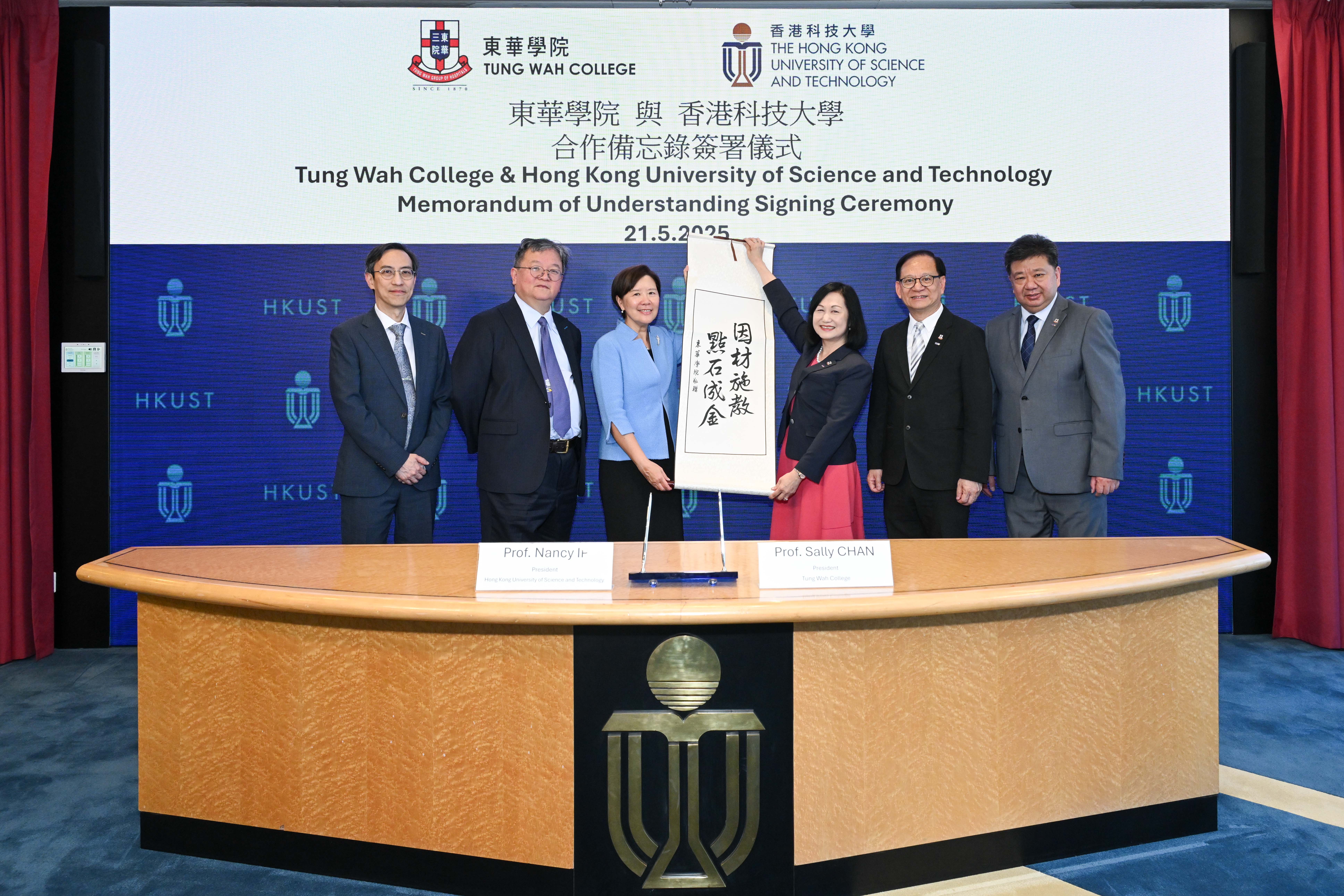 HKUST President Prof. Nancy Ip (third left), Provost Prof. GUO Yike (second left) and Dean of Science Prof. WONG Yung-Hou (first left) are presented with a symbolic Chinese calligraphy hanging scroll by Prof. Sally CHAN (third right), President of TWC, Prof. David MAN (second right), Vice President (Academic) of TWC, Dr. George LAU (first right), Vice President (Administration & Development) of TWC.  The inscription of the banner reads “Teaching students according to their aptitude, turning stones into gold