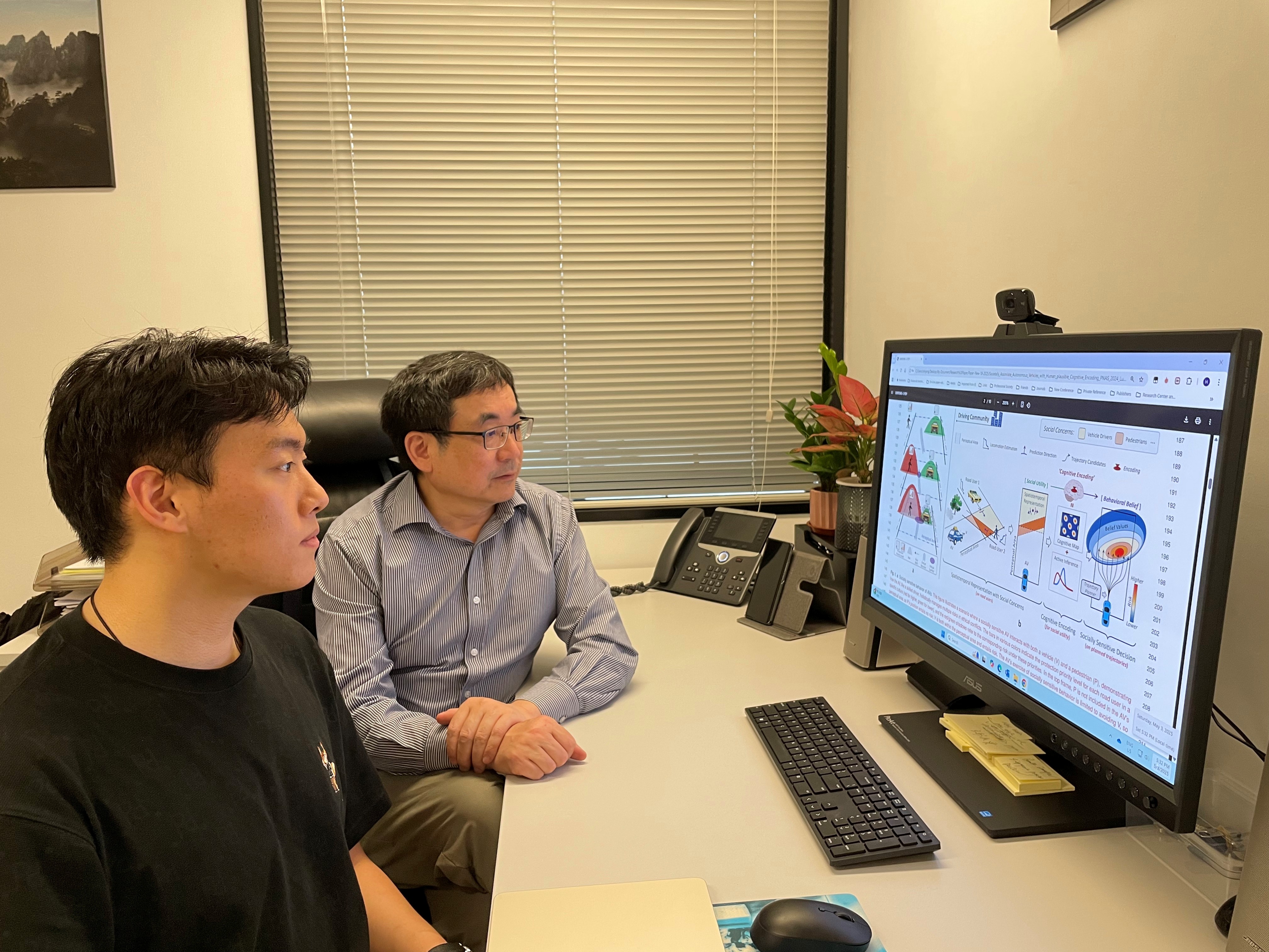 Prof. YANG Hai (right) discusses the research framework with LU Hongliang (left), the first author of the study.
