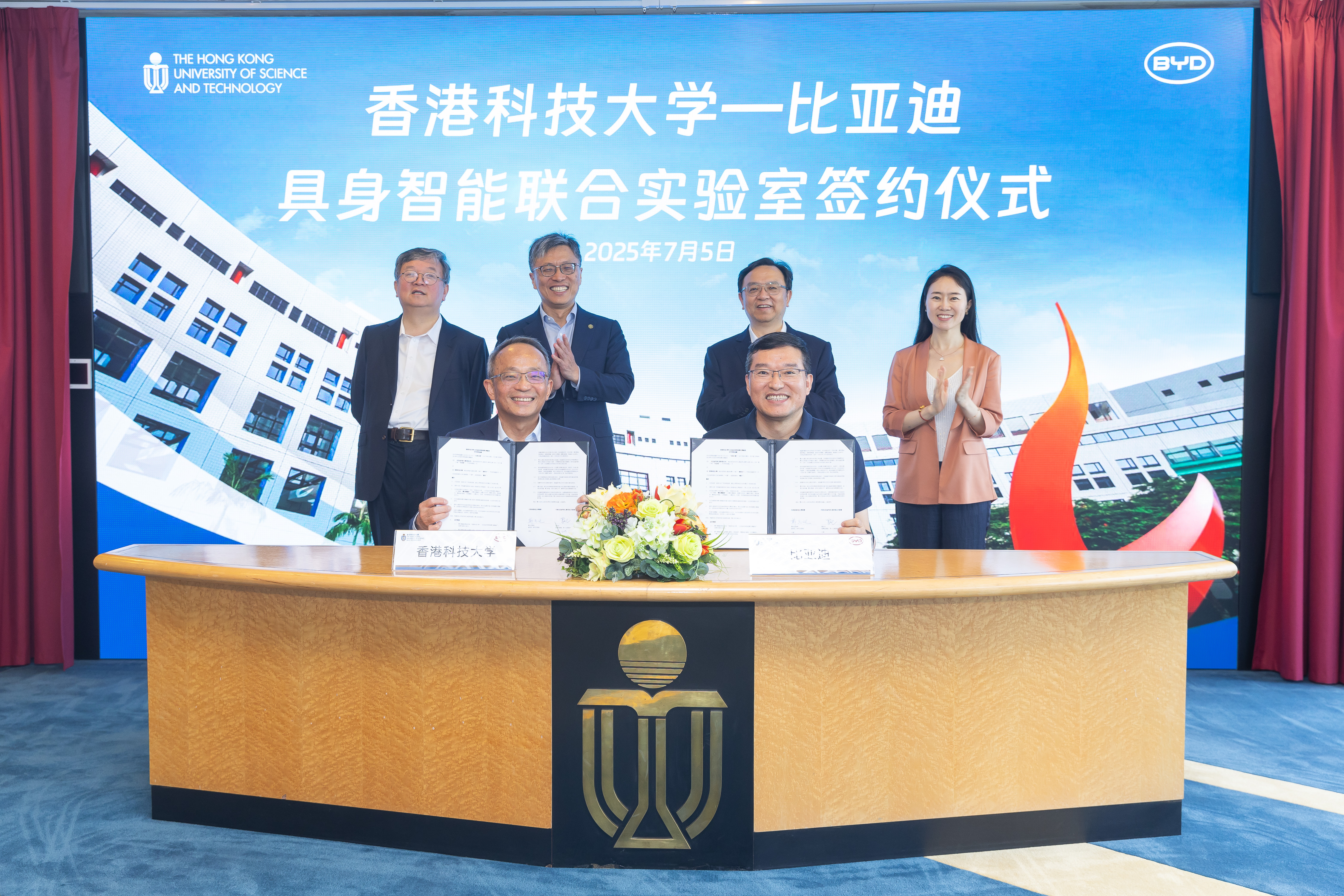 Witnessed by Prof. Harry SHUM (back row, second left), Mr. WANG Chuanfu (back row, second right), HKUST Provost Prof. GUO Yike (back row, first left) and BYD Vice President Ms. LI Wei (back row, first right), Prof. Tim CHENG (front left) and Mr. LUO Zhongliang (front right) sign the agreement.