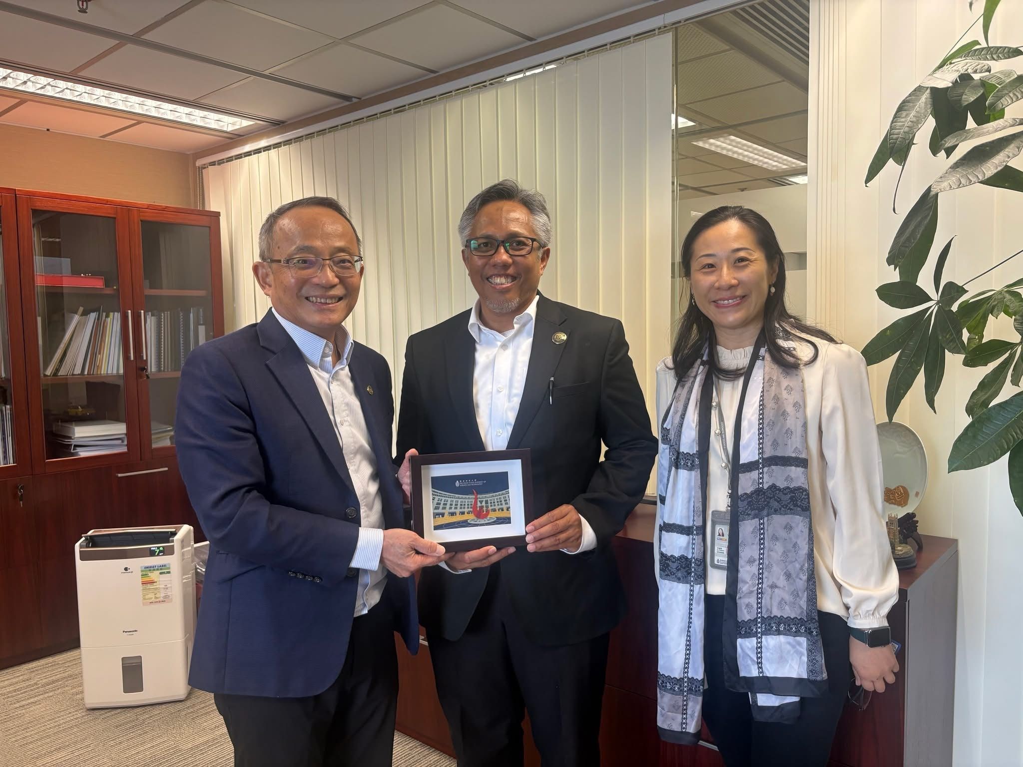 HKUST Vice-President for Research and Development Prof. Tim CHENG (first left) and Yvonne LI, Head of Global Engagement and Greater China Affairs, present a HKUST souvenir to the Institut Teknologi Bandung Rector Prof. Tatacipta DIRGANTARA (center).
