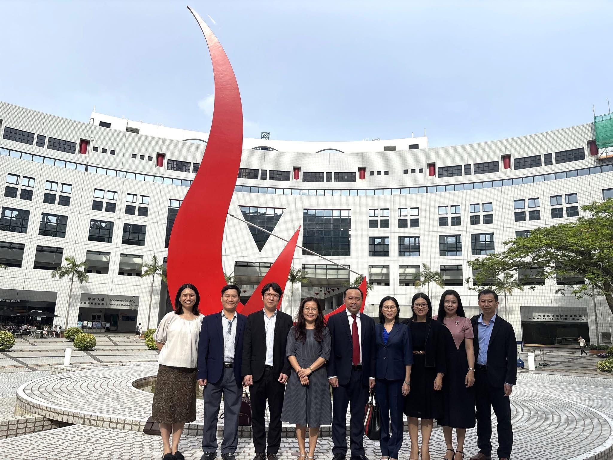 A group photo of the VNU-HCMC delegation in front of the iconic "Red Bird" sculpture at the Piazza.