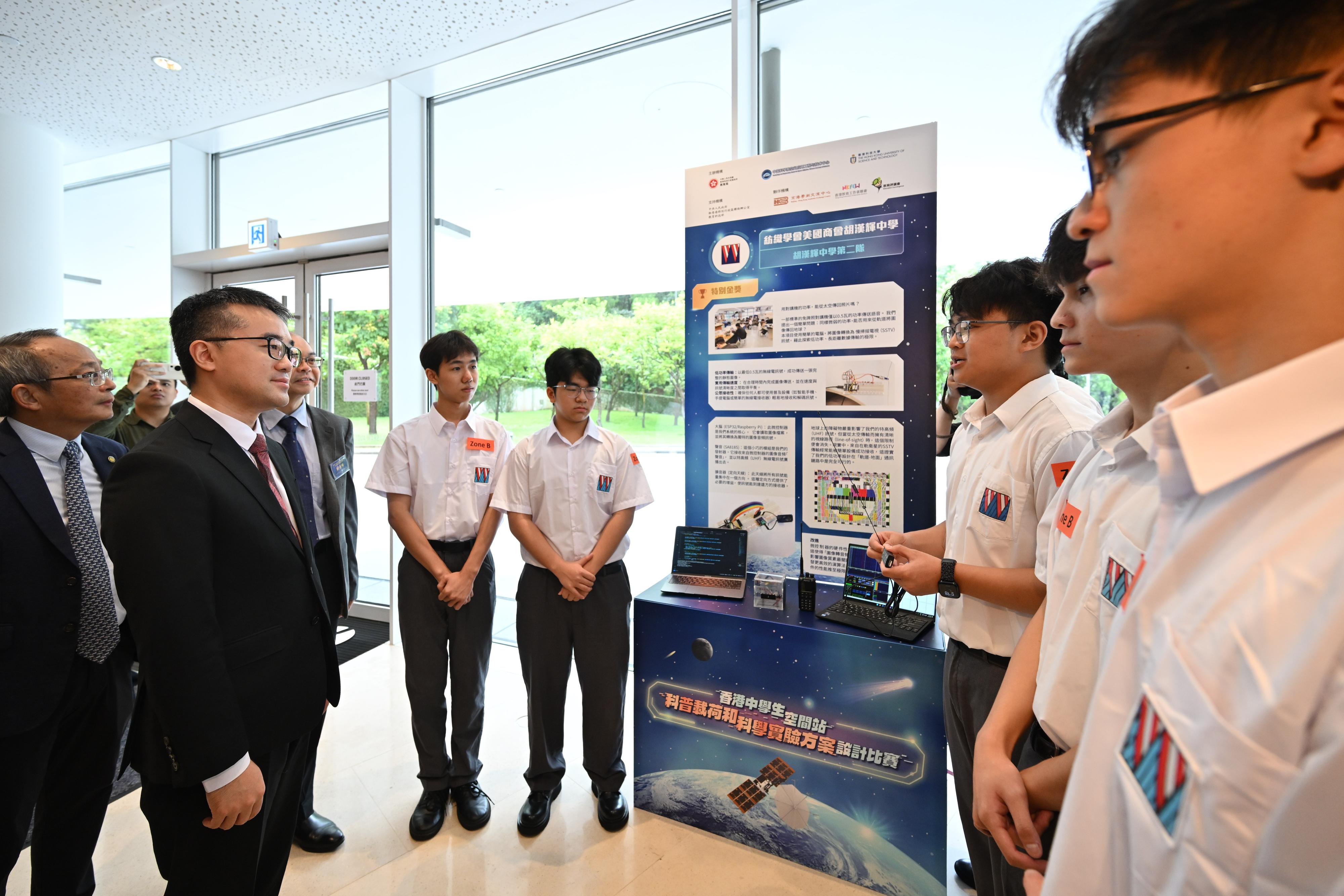 The Education Bureau held an award presentation ceremony for the Hong Kong Secondary Student Space Station Popular Science Payload and Science Experiment Design Challenge at the Hong Kong University of Science and Technology today (September 21). Photo shows the Under Secretary for Education, Dr Sze Chun-fai (second left), listening to students from a Gold Award-winning team, Team 2 of TIACC Woo Hon Fai Secondary School, introducing their proposal.