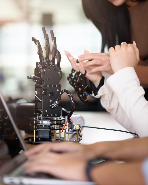 People working on a robotic hand