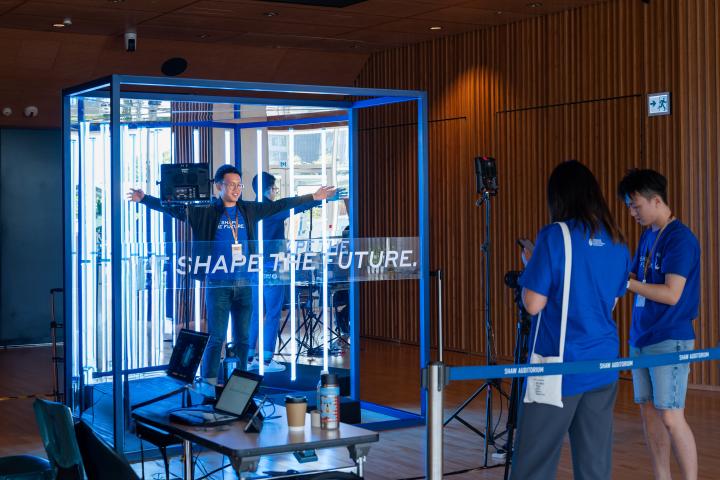 Man inside a box of mirrors and lights doing an experiment