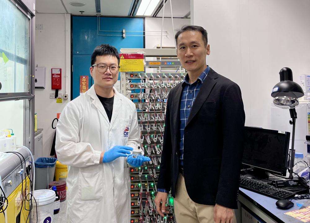 Prof. Yoonseob KIM (right), Associate Professor in the Department of Chemical and Biological Engineering and the study’s corresponding author, and his PhD student YIN Zhuoyu (left), the study’s first author, who is holding an electrochemical cell mold. They are pictured beside a battery cell cycler.